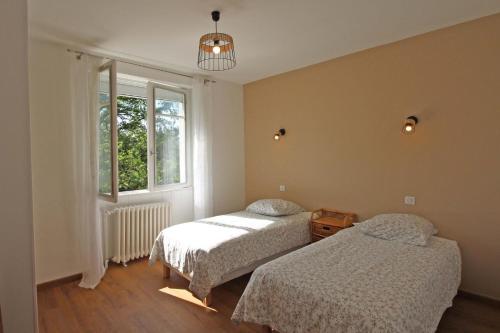 a bedroom with two beds and a window at La fontaine in Saint-Mathieu