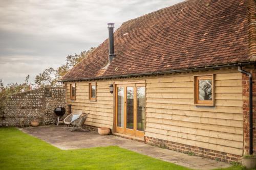 a small house with a patio in front of it at The Cowshed in Hooe