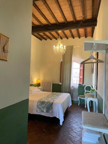 a bedroom with a bed and a chandelier at B&B Osteria Del Vicario in Certaldo