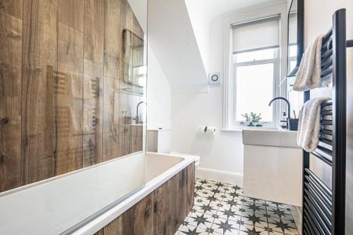 a bathroom with a tub and a sink at The Belmont Apart Hotel - Harrogate Stays with FREE PARKING in Harrogate