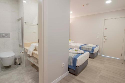 a bathroom with two beds and a sink and a toilet at Silver Hotel in Side
