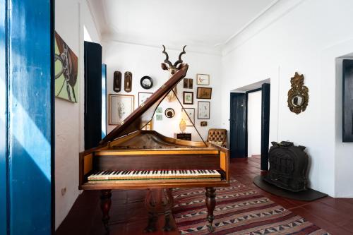 a piano in a living room with a wall at Eighteen21 Houses - Casa dos Condes in Cano