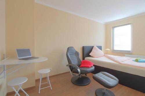 a small room with a bed and a desk with a laptop at Gästehaus Dorum 01 in Dorum