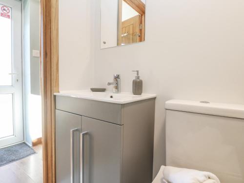 a white bathroom with a sink and a mirror at Blake Lodge in Newquay