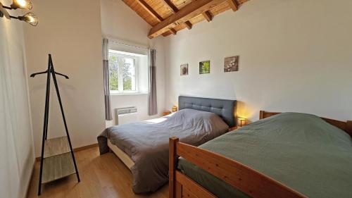 a bedroom with two beds and a telescope in it at Neuville in Saint-Mathieu