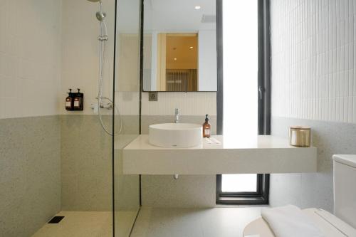 a bathroom with a sink and a glass shower at Koji House in Jakarta