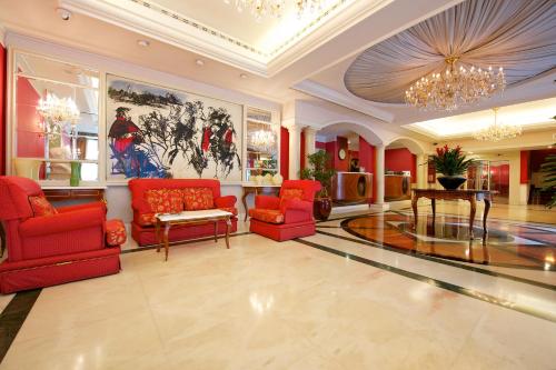 
a living room filled with furniture and a red carpet at Mercure Parma Stendhal in Parma
