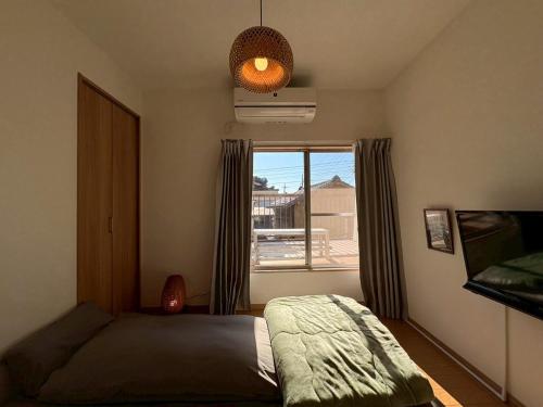 a bedroom with a bed and a window with a view at 青梅森の宿 in Ome