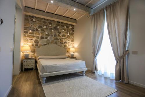 a bedroom with a bed and a stone wall at Hotel Art Al Boschetto in Castel Volturno