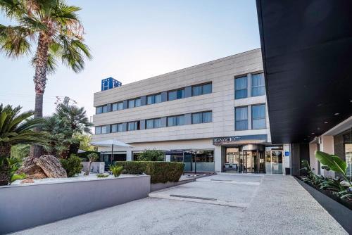 ein Gebäude mit einer Palme davor in der Unterkunft Hotel Ignacio - PalomarGroup in Chiva
