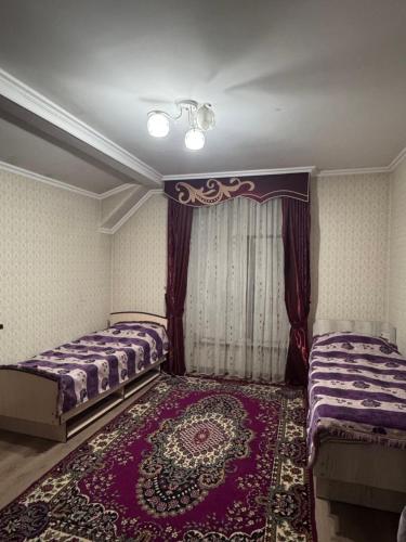 a bedroom with two beds and a rug at Mama Nuris guest house in Karakol