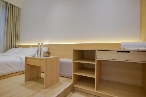 a bedroom with a bed and a desk and a bed at Koji House in Jakarta