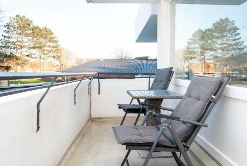 two chairs and a table on a balcony with a laptop at Hanseatic 111 in Duhnen