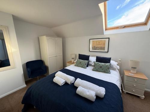 a bedroom with a large bed with two pillows at House Martin in Ipplepen