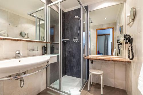 a bathroom with a sink and a shower at Hotel Alpenrose in Zauchensee