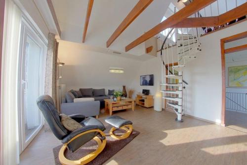 a living room with a couch and a stair case at KA8 Beim Wattn Fischer in Wremen