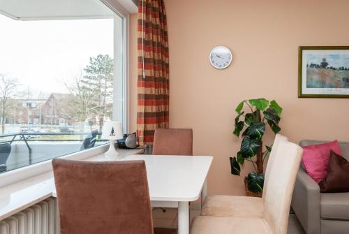 a room with a table and chairs and a window at Hanseatic 210 in Duhnen