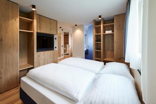 a bedroom with two beds and wooden shelves at Alpe di Susi in Castelrotto