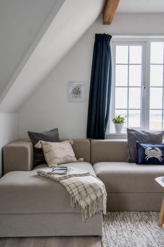 a living room with a couch and a window at 1 Quay Cottage in Bawdsey