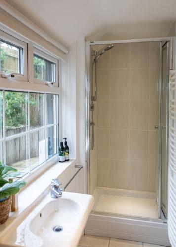 a bathroom with a shower and a sink at 1 Quay Cottage in Bawdsey