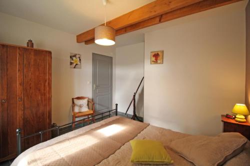 a bedroom with a bed and a chair at La chaudière in Saint-Auvent