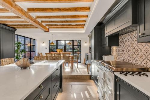 a kitchen with black and white cabinets and a dining room at Marsh Mallow Cottage - Hot Tub Packages Available in Loughborough