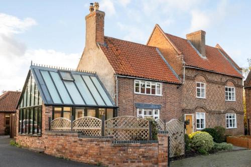 an old brick house with a tiled roof at Dovecote Farmhouse in West Leake