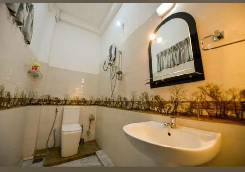 a bathroom with a sink and a mirror on the wall at Wounder Mountain view ella in Medaperuwa