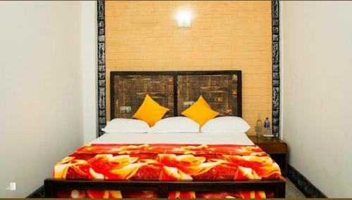 a bedroom with a large bed with yellow pillows at Wounder Mountain view ella in Medaperuwa