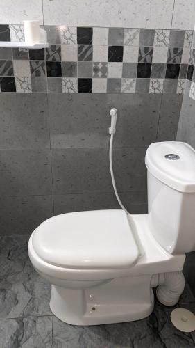 a white toilet with a hose attached to it in a bathroom at Vista villa in Panama