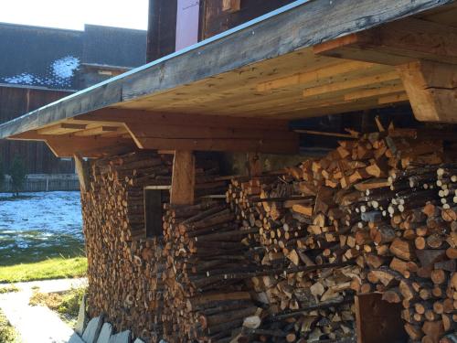 a pile of fire wood under a building at Chalet Nidus Montis in Wergenstein