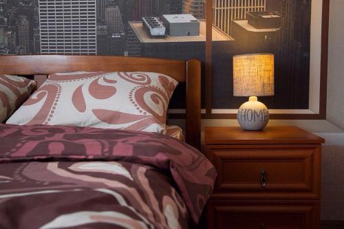 a bedroom with a bed and a table with a lamp at Apartment-Lawina in Sumy