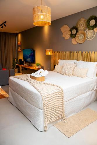 a bedroom with a large white bed and a tv at Studio River 101 in Pôrto de Pedras