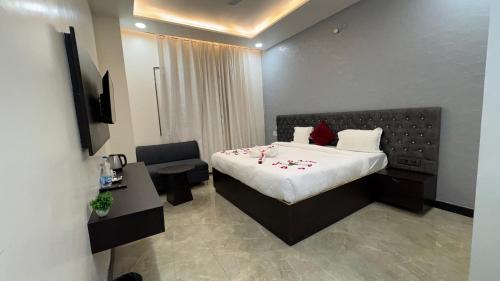 a bedroom with a bed and a desk and a chair at Status Club in Hardoī