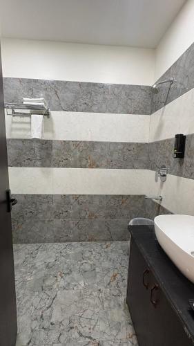 a bathroom with a sink and a counter with a sink at Status Club in Hardoī