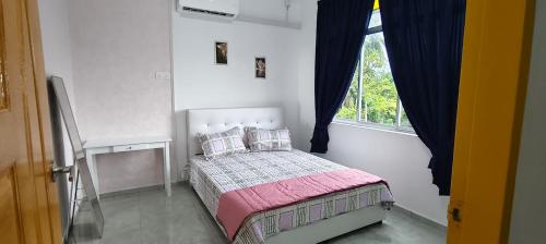 a small bedroom with a bed and a window at Tetiba Suite in Muar