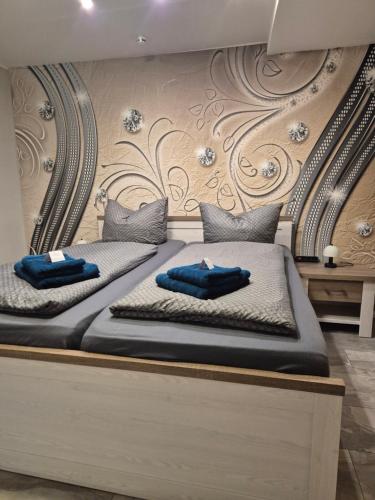 two beds with blue pillows on them in a room at Ferienwohnung Puchfrie in Bad Sooden-Allendorf