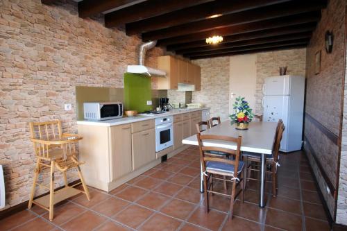 a kitchen with a table and chairs in a room at Vedeix in Saint-Auvent