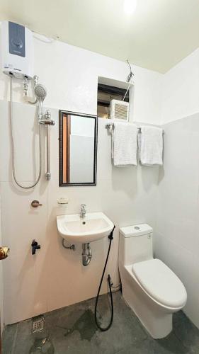 ein Badezimmer mit Toilette und Waschbecken in der Unterkunft Lucy's Tiny Homes in Puerto Princesa