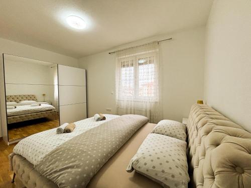 a bedroom with two beds and a mirror at Apartman Sučić in Livno