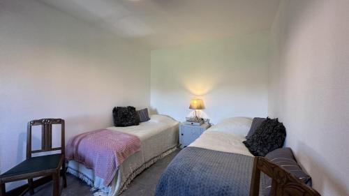 a small room with two beds and a lamp at Le gîte de nathye in Saint-Junien