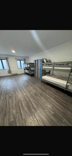 an empty room with two beds and a wooden floor at Dublin Quayside Hostel in Dublin