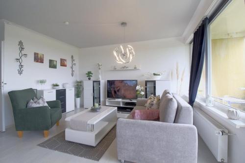 a living room with two chairs and a tv at Apartment 256 in Hohegeiß