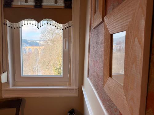 a window with a curtain in a bathroom at Antique Hotel Am Bahndamm in Wallendorf