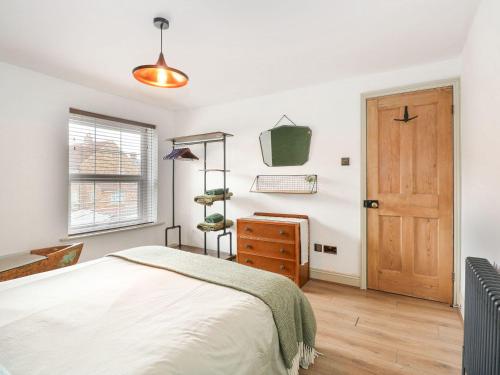 a bedroom with a bed and a wooden door at Joy's Cottage in King's Lynn