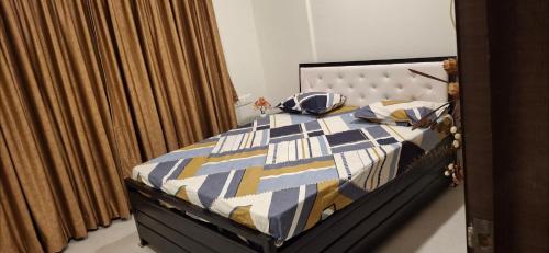 a bedroom with a bed with a blue and yellow quilt at Soni & Avi View Apartment in Igatpuri