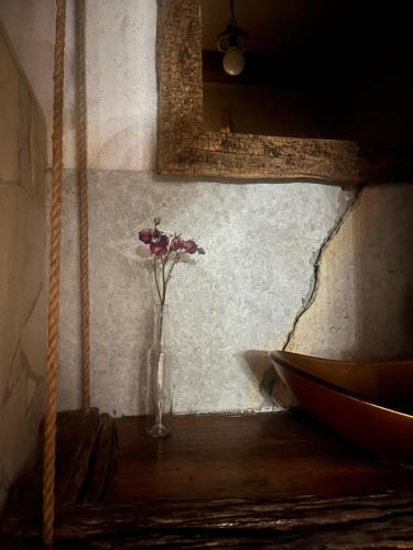 a vase with flowers in a room with a mirror at Casa Picătura de Rouă in Beliş