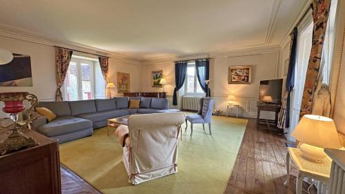 a living room with a blue couch and a table at Domaine de gensignac in Séreilhac