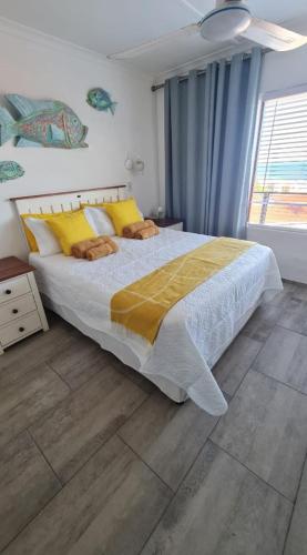a bedroom with a large bed with yellow pillows at Corona Del Mar 23 in Uvongo Beach
