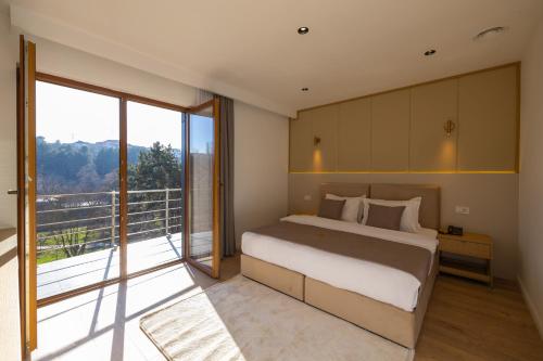 a bedroom with a large bed and a balcony at Hotel Allegra in Prishtinë
